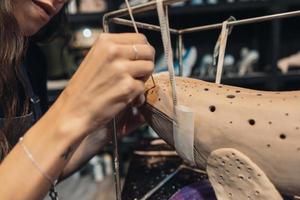 Close-up view of female hands gently handling a clay whale in workshop. photo