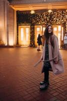 Girl on the background of the illuminated entrance to the building photo