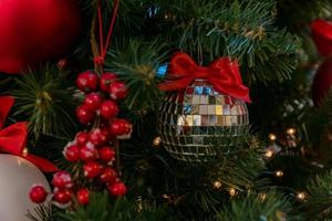 Silver disco bauble on a christmas tree. Festive greeting card for winter celebration. New year presentation photo