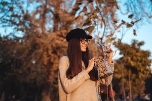 Beautiful young girl with handbag posing on camera photo