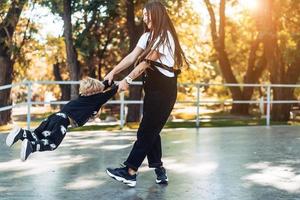 Mom and little boy cheerfully spinning around together. photo