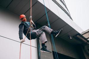 Industrial climber in uniform and helmet rises photo