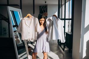 hermosa chica tratando de vestirse en la habitación foto