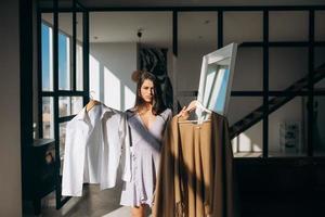 Beautiful girl trying dress in room photo