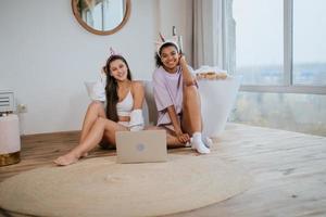 Young women on the bathroom floor looking at a camera photo