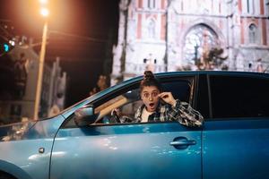 Woman driving car by night in the city photo