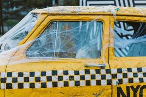 Old retro yellow taxi decorated with cobwebs photo