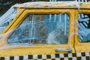 Old retro yellow taxi decorated with cobwebs photo