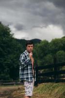 Guy by a fence of pasture enjoying nature. photo