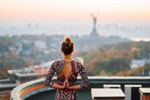 mujer haciendo yoga en la azotea de un rascacielos en la gran ciudad. foto