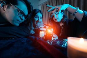 Group of people and woman fortune teller with crystal ball photo