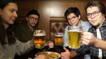 jóvenes amigos divirtiéndose juntos bebiendo cerveza en un pub. foto