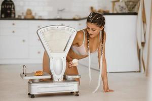 Woman in lingerie posing at the old grocery scales. Healthy eating concept photo