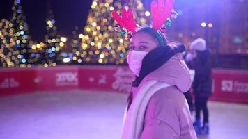 People enjoy ice skating in the street around Christmas tree in rink. photo