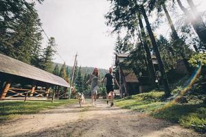 couple runs on road in the nature with dog photo