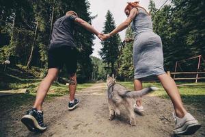 couple runs on road in the nature with dog photo