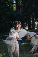 Beautiful woman with playful young dogs on fresh green meadow photo