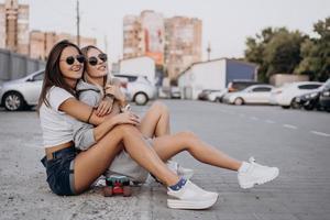 Two young, sexy girls are sitting on the ground photo