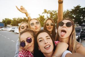 Six young beautiful girls looking at the camera and taking a selfie photo