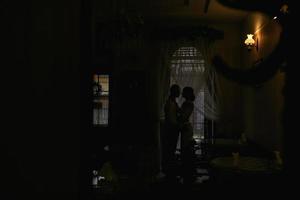 Beautiful couple's silhouette in the window photo