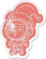 cartoon distressed sticker of a astronaut man wearing santa hat vector