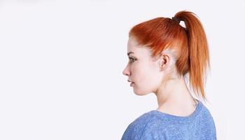 young woman with dyed red hair tied back in a ponytail with scrunchie photo