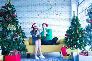 Merry Christmas and New Year concept. Young Caucasian lover with christmas theme clothing celebrate and exchange presents each other in the party with fun and happiness photo