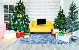 concepto de vacaciones de navidad y año nuevo. decoración de árboles de navidad con cintas de tablero negro bolas copos de nieve y adornos y cajas de regalo sobre pared de ladrillo blanco prepararse para la fiesta nocturna foto