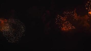 lindo fogo de artifício explodindo no céu escuro. muitas luzes coloridas brilhantes. saudação comemorativa. show pirotécnico em homenagem ao ano novo. 4º dia da independência. 4 de julho video