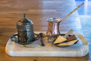Turkish coffee being made in a traditional way with sweets.  Traditional serving coffee photo
