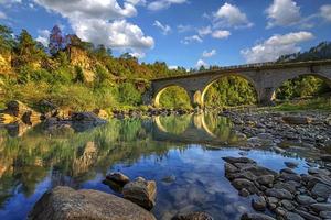 vista asombrosa del río pacífico y el viejo puente de piedra foto