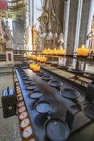 Candles in the Church. Votive prayer candles inside a catholic church on a candle rack. photo