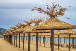 sombrillas de madera de belleza de playa de arena vacía foto