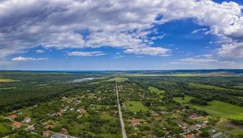 panorama aéreo desde un dron de campo, pueblo, campos verdes y árboles, concepto de agricultura. tierras de cultivo foto