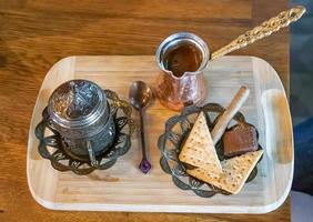 Turkish coffee being made in a traditional way with sweets.  Traditional serving coffee photo