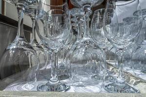 Rows of empty wine glasses close up. Glass goblets on the white table. Restaurant bar concept photo