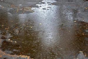 Rain water drops falling to the city street floor in autumn rainy day photo