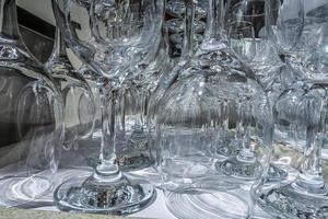 Rows of empty wine glasses close up. Glass goblets on the white table. Restaurant bar concept photo