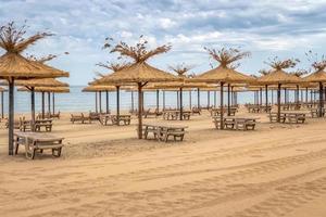 playa de arena vacía y filas de lugares de descanso en la fallida temporada turística. foto