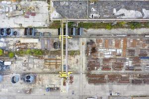 aerial view from drone of factory warehouse of steel elements and crane photo