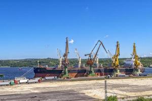 Trucks with grain waiting for unloading near the ship. Work in port photo