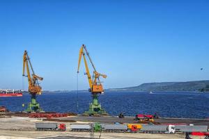 Port cranes ready to load containers from cargo ships. horizontal view photo