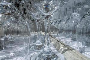 Rows of empty wine glasses close up. Glass goblets on the white table. photo