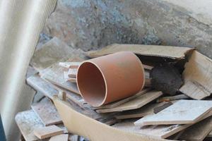 sewer pipe and fragments of ceramic tiles, construction debris after house renovation photo