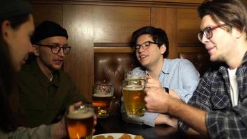 hora feliz en el bar, los chicos beben cerveza y comen aperitivos video