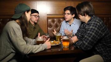 happy hour au bar, les garçons boivent de la bière et mangent des apéritifs video