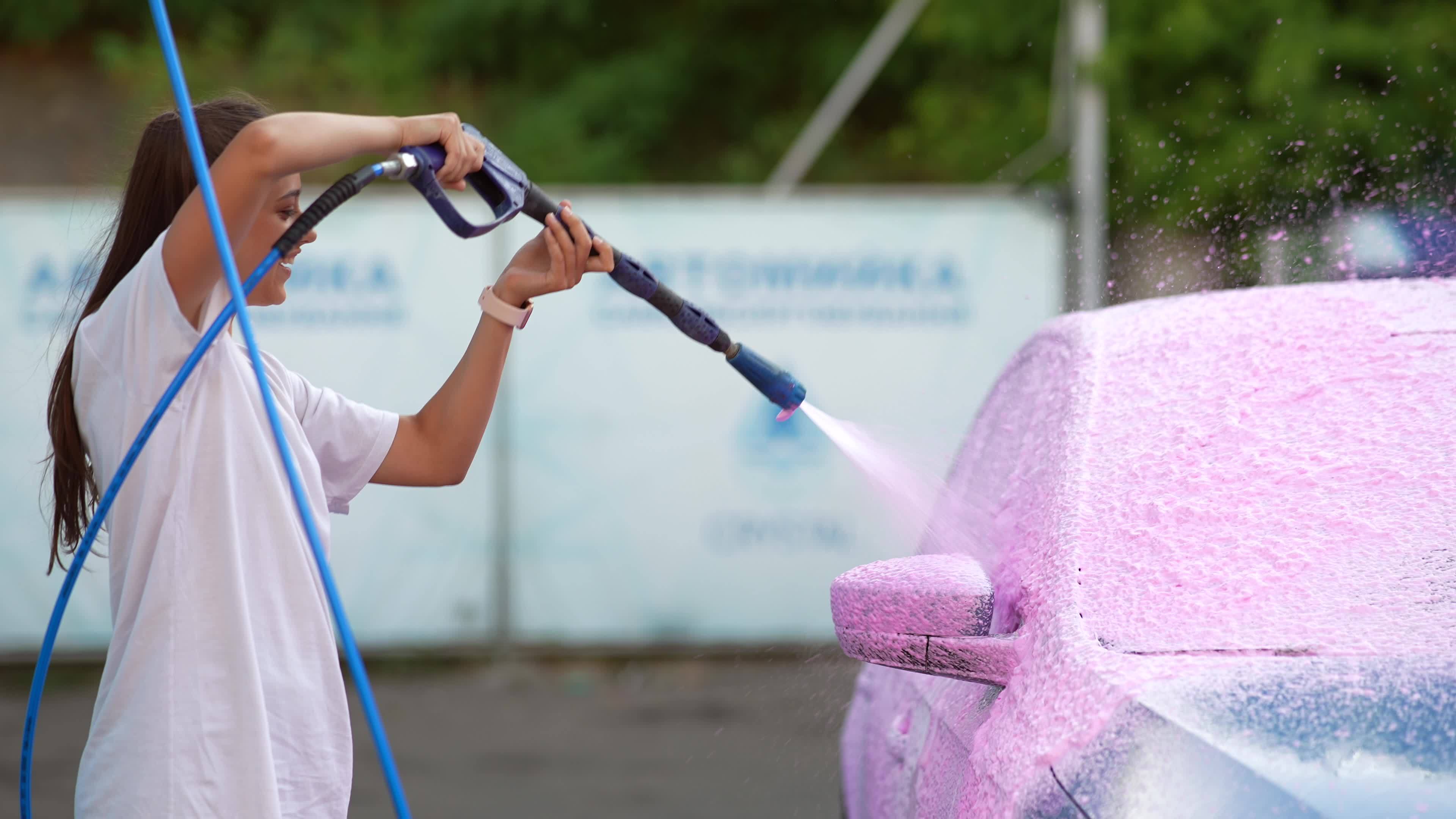 Young woman washing car with a pink foam 11801581 Stock Video at Vecteezy