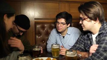 hora feliz en el bar, los chicos beben cerveza y comen aperitivos video