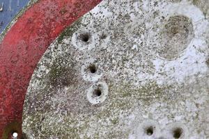 Detailed close up of bullet holes from gun shots in a traffic sign photo