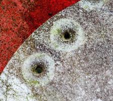 Detailed close up of bullet holes from gun shots in a traffic sign photo